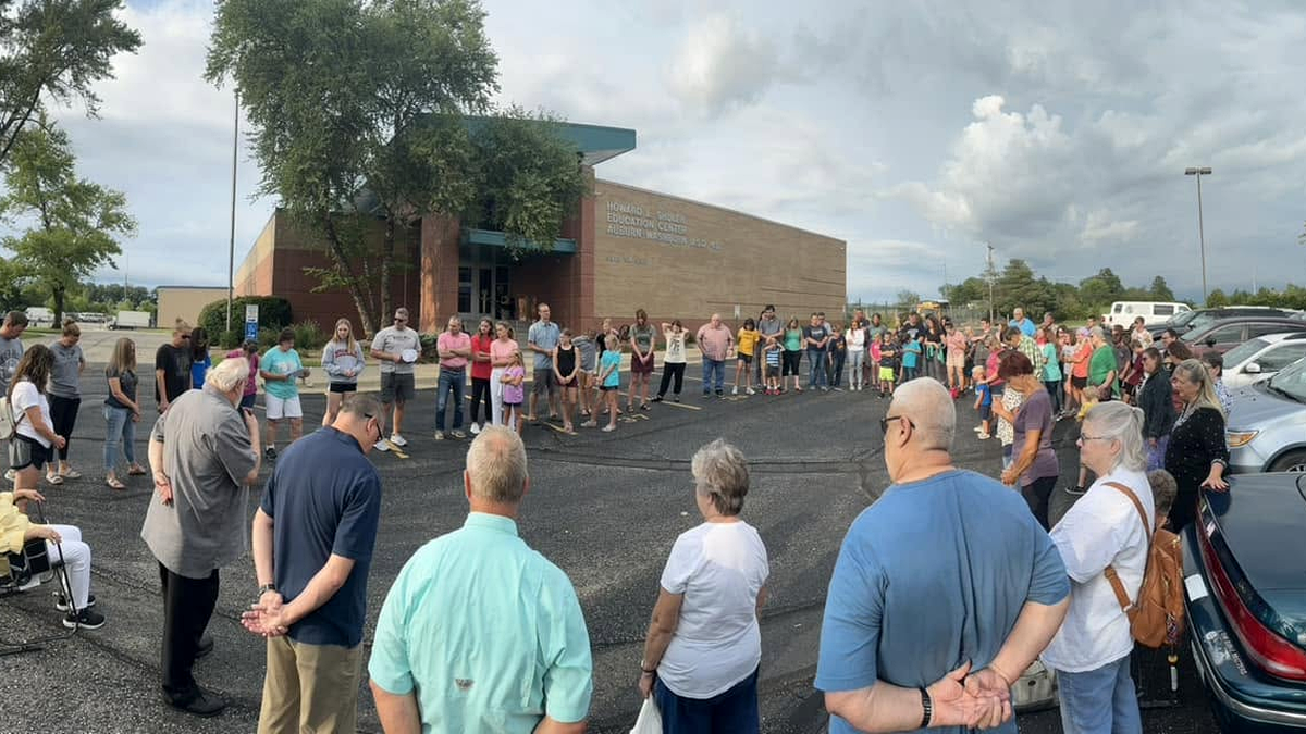 Maranatha Baptist Fellowship members gathered outside a local high school to pray for area schools